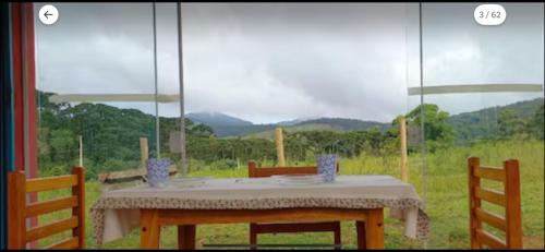 a table and chairs with a view of a field at Lavandário do Sertão in Gonçalves
