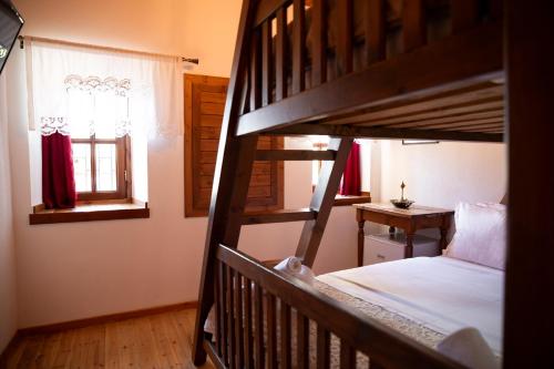 a bedroom with two bunk beds and a window at Hotel Sarajet 1821 in Gjirokastër