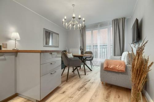 eine Küche und ein Esszimmer mit einem Tisch und einem Kronleuchter in der Unterkunft Apartamenty MUNN 3 Szczecin in Stettin