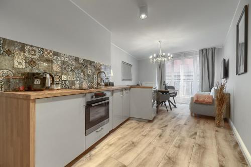 eine Küche mit weißen Schränken und ein Esszimmer in der Unterkunft Apartamenty MUNN 3 Szczecin in Stettin