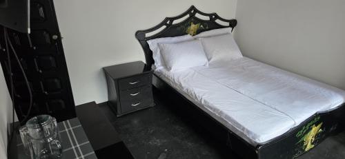 a bed with a black headboard and a night stand at Hotel Migración in Bogotá