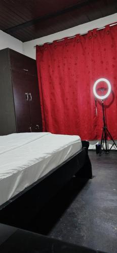 a bedroom with a bed and a red curtain at Hotel Migración in Bogotá