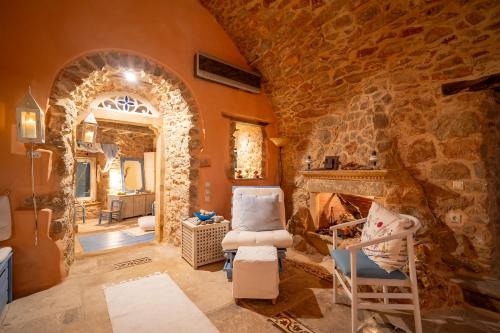 a living room with a stone fireplace and chairs at Aretis Stone Retreat 