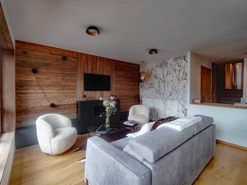 un salon avec un canapé, des chaises et une télévision dans l'établissement Homency - Résidence L'Expression B31, à L'Alpe-d'Huez