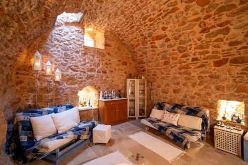 a living room with two chairs and a stone wall at Aretis Stone Retreat 