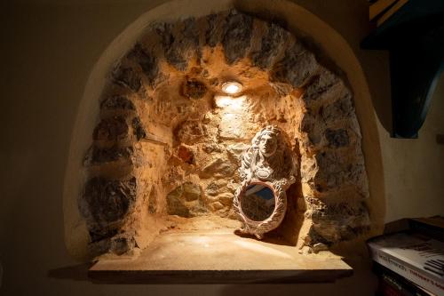 a statue of a skeleton sitting in a stone archway at Aretis Stone Retreat 