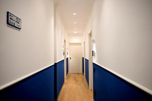 een hal met blauwe en witte muren en een deur bij Omnia Luxury Suite in Salerno