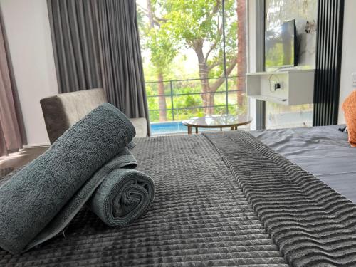 a bedroom with a bed with a blanket and a window at Leopard Inn Wilpattu in Ilavankulam