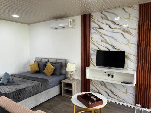 a bedroom with a bed and a tv on a wall at Leopard Inn Wilpattu in Ilavankulam
