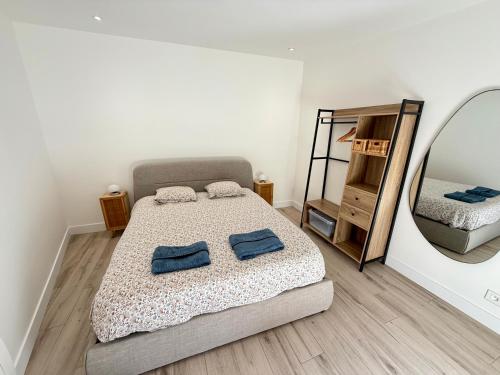 une chambre avec un lit et un miroir dans l'établissement Maison Les Sables d'Olonne - Quartier Gare, à Les Sables-dʼOlonne