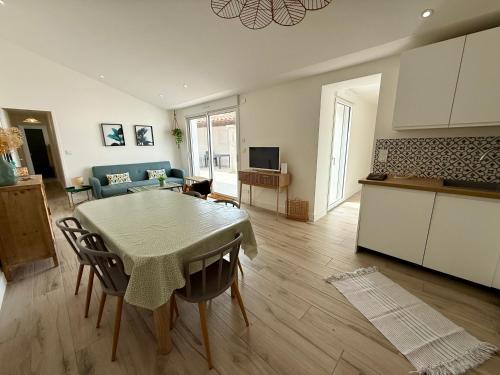 une cuisine et un salon avec une table et des chaises dans l'établissement Maison Les Sables d'Olonne - Quartier Gare, à Les Sables-dʼOlonne