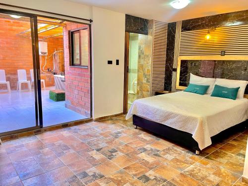 a bedroom with a bed and a walk in shower at Hotel Torre Primavera in Medellín