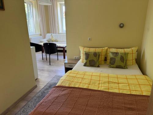 a bedroom with a bed with a yellow blanket on it at Gasthaus Jungwirth - Family Boutique Pension in Wanghausen