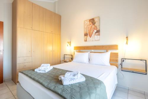 a bedroom with a bed with towels on it at Sofia's seaview house in Platanias
