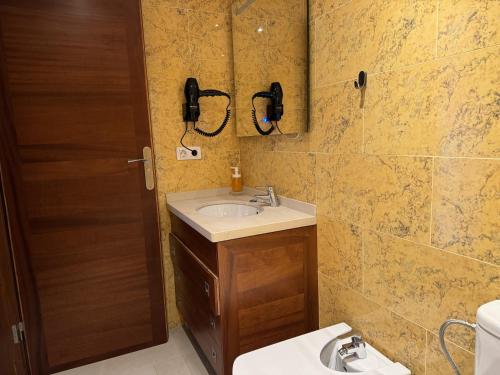 a bathroom with a sink and a phone on the wall at Casa Maricarmen villa in Tacoronte