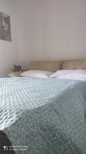 a bedroom with a bed with a blue comforter at Casa Adele in Grugliasco