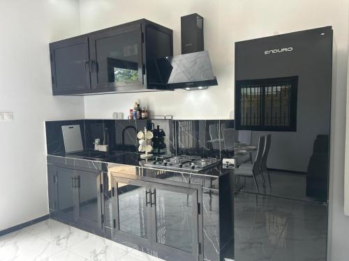 RufisqueにあるVilla climatisé avec piscine et calmeのキッチン(黒いキャビネット、カウンタートップ付)