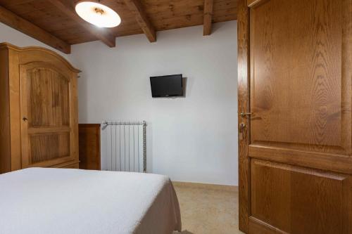 a bedroom with a bed and a tv on a wall at B&b Gennargentu in Fonni
