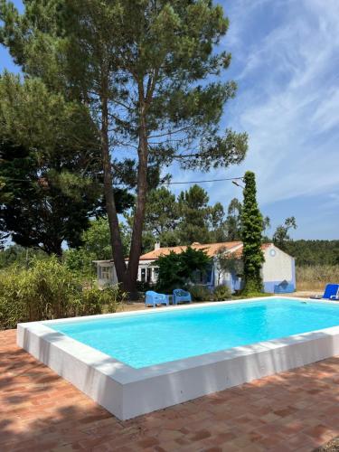 a swimming pool in front of a house at Quintal Alentejano in Fataca