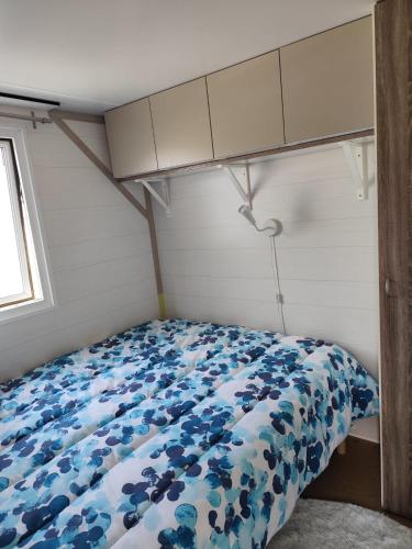 a bedroom with a bed with a blue floral comforter at La Lavande in Sorgues