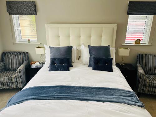 a large white bed with blue pillows in a bedroom at Wendys house in Sarisbury Green