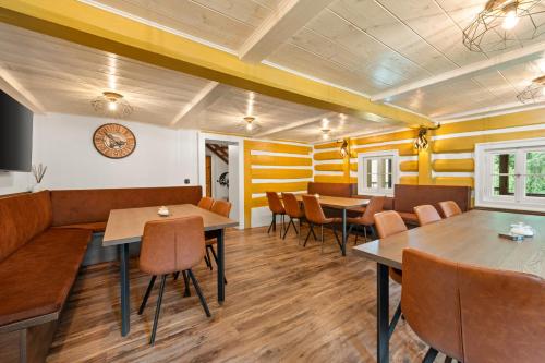 a restaurant with tables and chairs and a clock on the wall at Chalupa Sport Buřany in Jablonec nad Jizerou