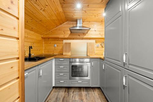 a kitchen with gray cabinets and a stove at Chalupa Sport Buřany in Jablonec nad Jizerou