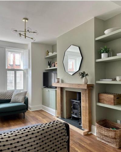 a living room with a fireplace and a mirror at Emerson House, dog friendly with log burner close to waters edge and harbour in Poole