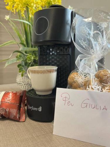 a coffee maker sitting on top of a table with a sign at Casa Adele in Grugliasco