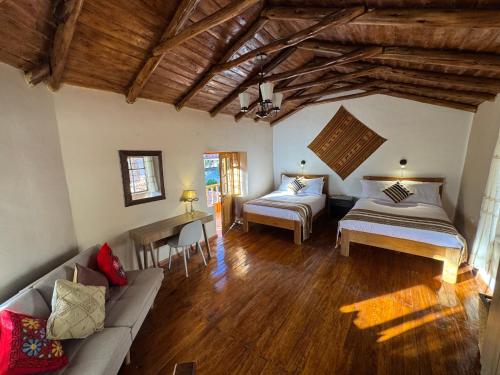 ein Wohnzimmer mit zwei Betten und einer Couch in der Unterkunft Urquillos Wasi - Andean Cottage in Urubamba