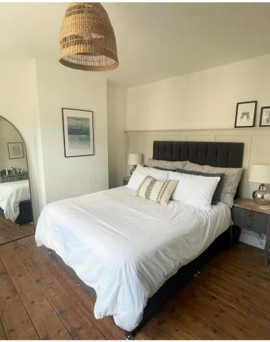a bedroom with a large white bed with two pillows at Emerson House, dog friendly with log burner close to waters edge and harbour in Poole