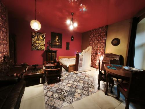 a bedroom with a bed and a desk and a table at Sekret Maharadży - The Maharaja's Secret in Częstochowa