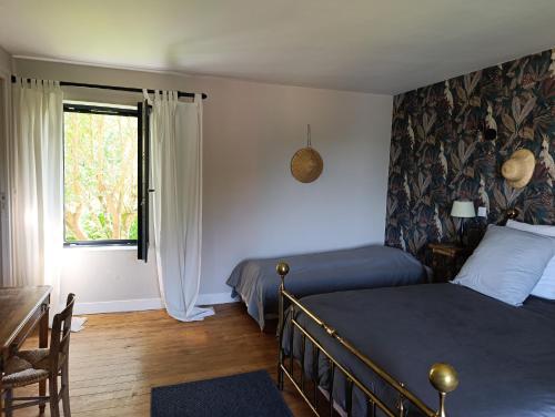 une chambre avec deux lits et une fenêtre dans l'établissement L'Henridette, à Quévreville-la-Poterie
