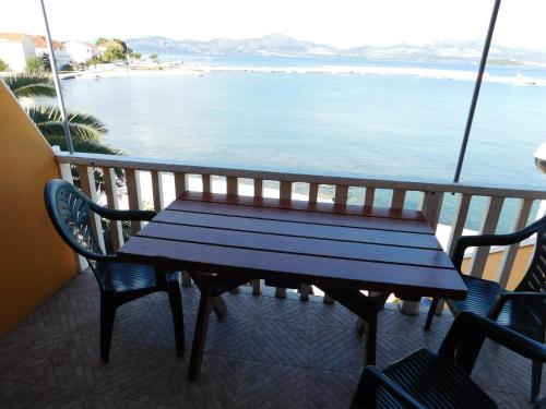 a blue bench sitting on a balcony overlooking the ocean at Apartments Kalafatović in Drače