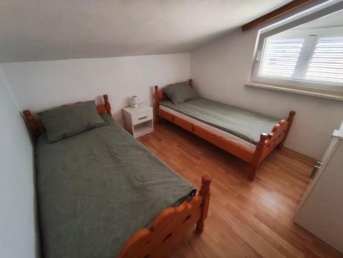 a bedroom with two beds and a window at Apartment Vir in Vir