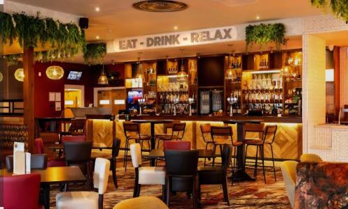 a bar with tables and chairs in a restaurant at E11 caravan sand le mere holiday park in Tunstall