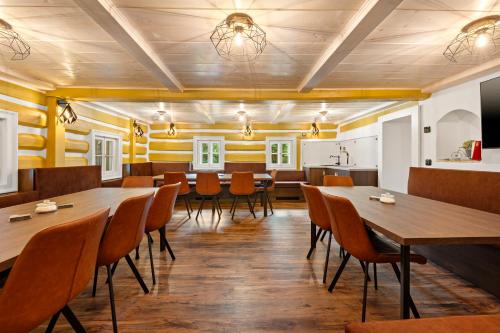 a restaurant with wooden floors and tables and chairs at Chalupa Sport Buřany in Jablonec nad Jizerou