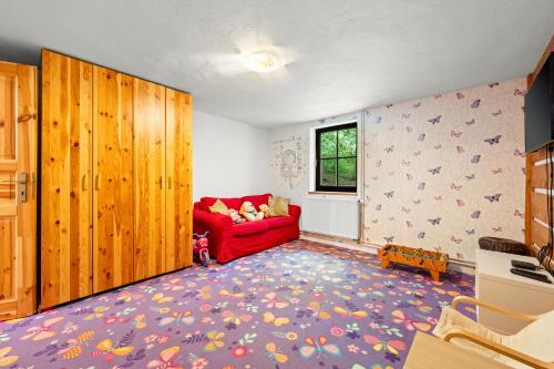 a living room with a red couch and a window at Chalupa Sport Buřany in Jablonec nad Jizerou