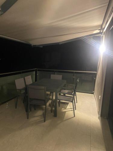 a table and chairs on a balcony with a light at Alata Appartement T3 in Alata