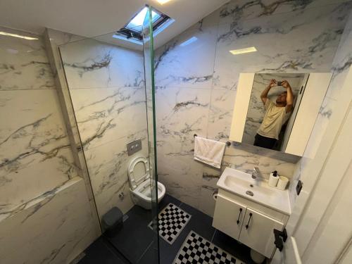a man is taking a picture of a bathroom at Bodrum Center 2plus1 for 6 people - Citak Mansions in Bodrum City
