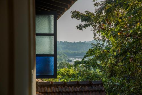 a window with a view of a river and trees at Wildflower Villas - All Villa Hotel, Family Run in Candolim