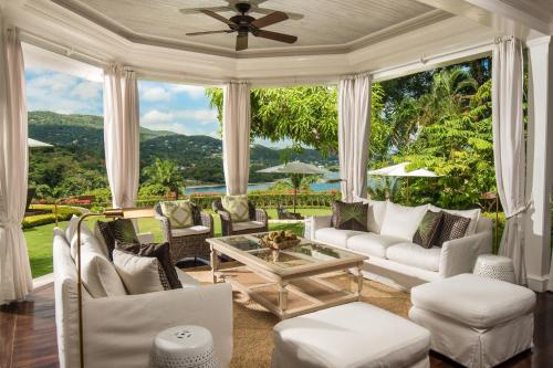 a living room with white furniture and a large window at Round Hill Hotel & Villas in Montego Bay