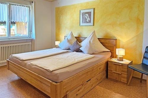 a bedroom with a large bed with white sheets and pillows at Haus Rümmele - Ferienwohnung 2 in Fröhnd