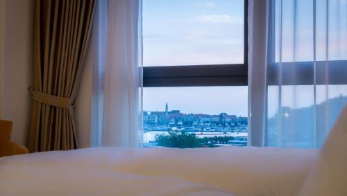 a bedroom with a window with a view of a city at Luxury Budva Center Apartments in Budva