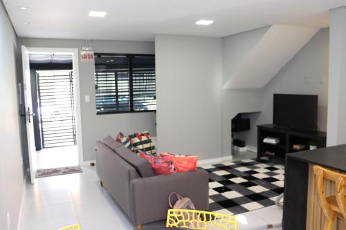 a living room with a couch and a tv at A 700m da Praia e do Shopping, Liberdade, Churrasq, Garagem e Estaciona Livre in Balneário Camboriú