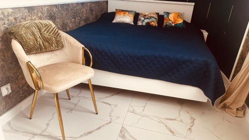 a bedroom with a bed and a chair at Apartament Azzurro - Old Town in Kłodzko