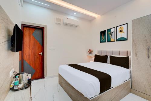a bedroom with a large bed and a television at Hotel O Airport Suites in Muthugadahalli