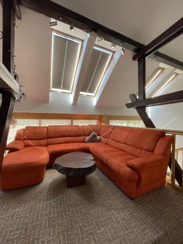 a brown leather couch in a room with windows at Munich Residence in Cristian