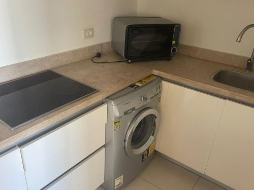 eine Küche mit Waschmaschine und Mikrowelle in der Unterkunft 3 bedroom apartment Marina Residence New Alamein in El-Alamein