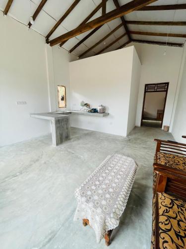 a white room with a table and a bench at The luxy bay in Arugam Bay